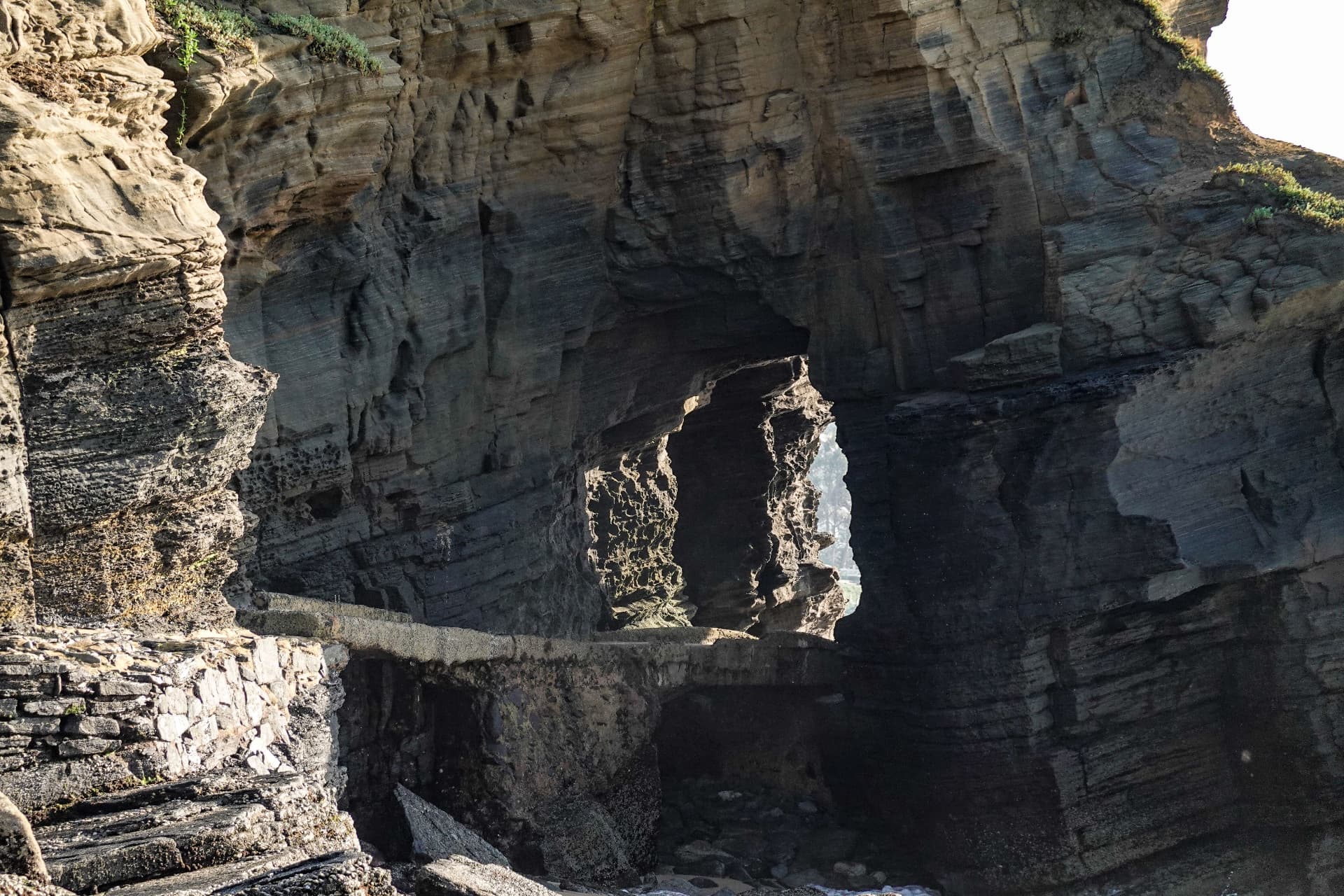 The Hole in the Wall: a sea-carved arch through the sandstone cliff beside the Thompson's Bay tidal pool